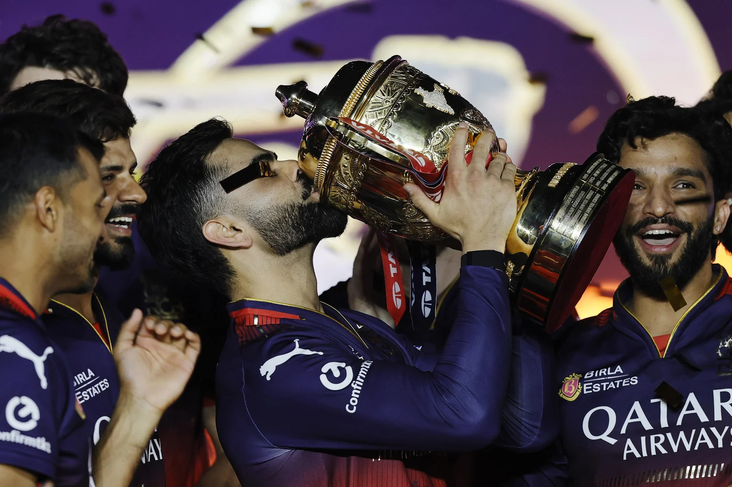 Virat Kohli celebrating with IPL trophy — the glamour side of IPL earnings that everyone sees