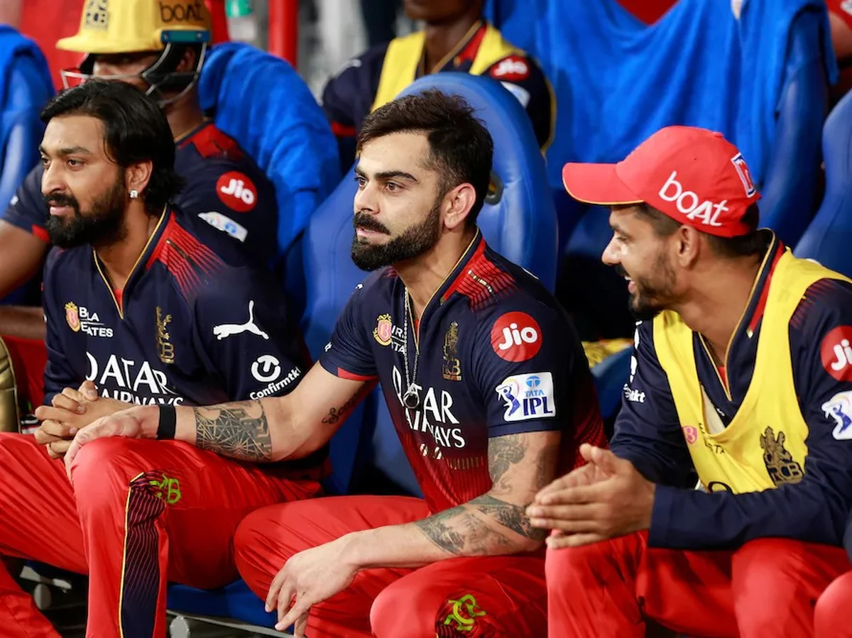 Substitute players sitting on the bench watching a cricket match